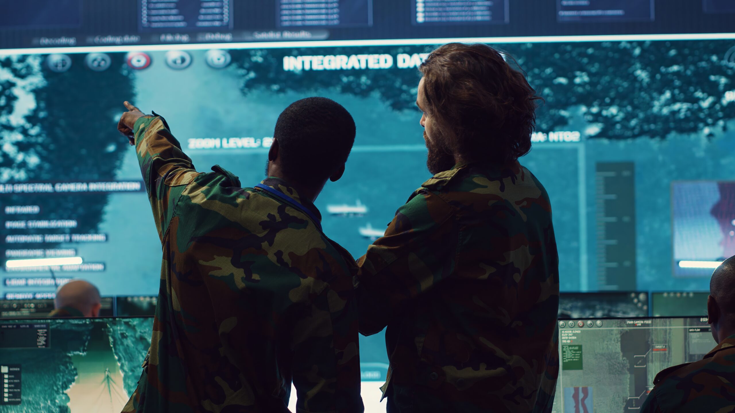 Diverse team of military personnel examining gathered information from CCTV satellite footage, transmitting crucial data to field troops. Army officers work on defense in command center. Camera A.